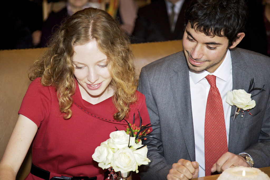 Le couple de mariés souriant, côte à côte, signant les actes de leur mariage civil, à Vevey, en Suisse.