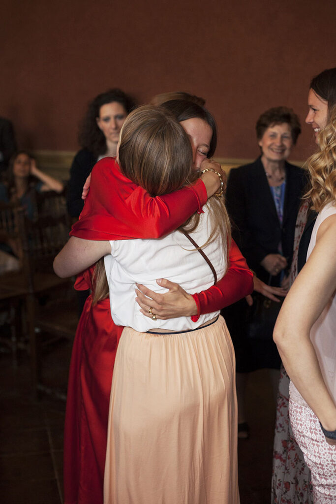 La mariée juste après la cérémonie serrant des ses bras une amie.
