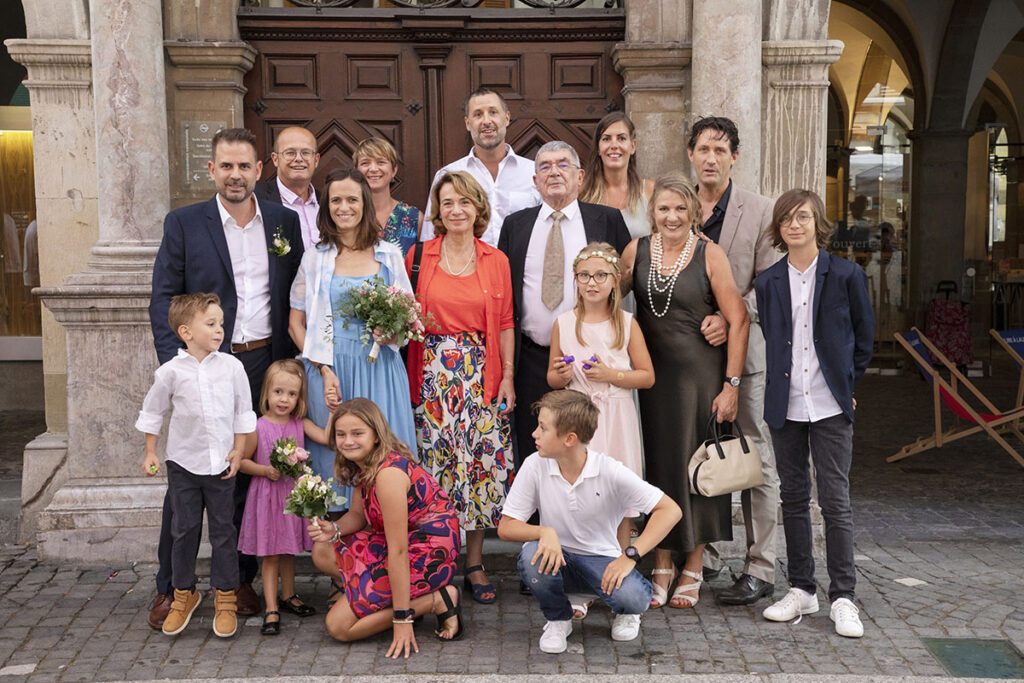 Photographie de groupe après la cérémonie de mariage devant l'Hôtel de Ville de Lausanne.
