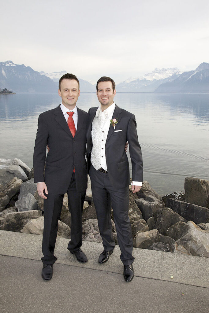 Le marié avec son témoin, heureux, pose fièrement devant le lac Léman à Vevey.