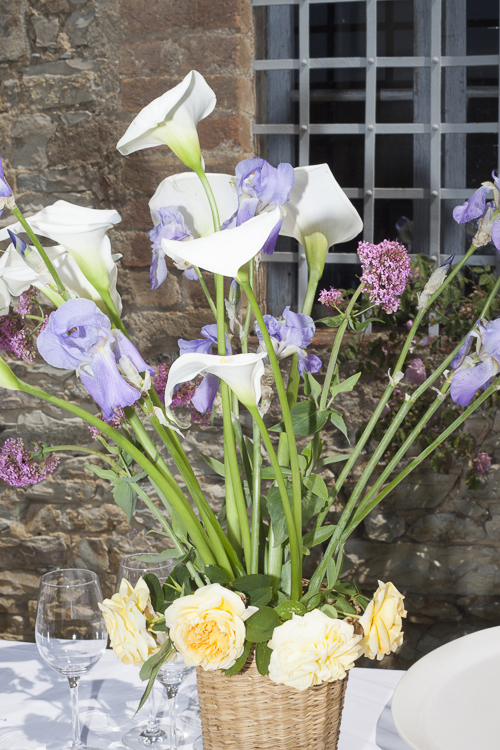 Bouquet de fleurs flashé, posé sur une table, pendant le repas du mariage à Sienne.